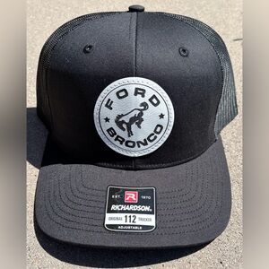 Black leatherette trucker hat with custom design